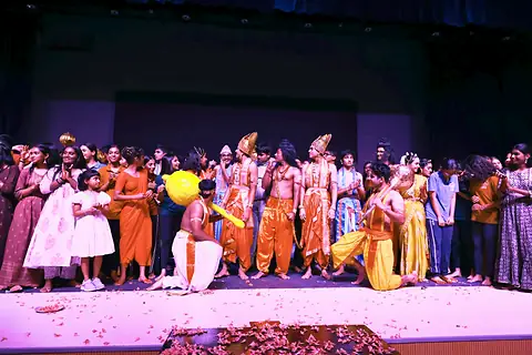 The cast crowded together on the stage at the close, petals on the floor