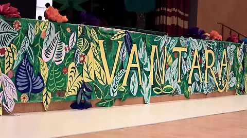 A painted banner of jungle leaves reading Vantara along the front of the stage