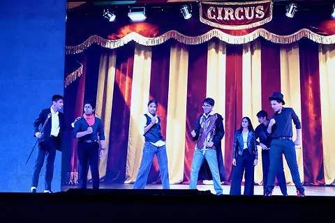 The company in a line before red-and-white striped curtains, beneath a sign reading Circus