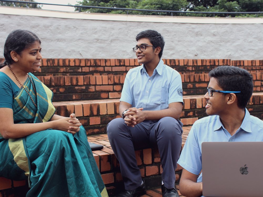A student speaking with members of the school team