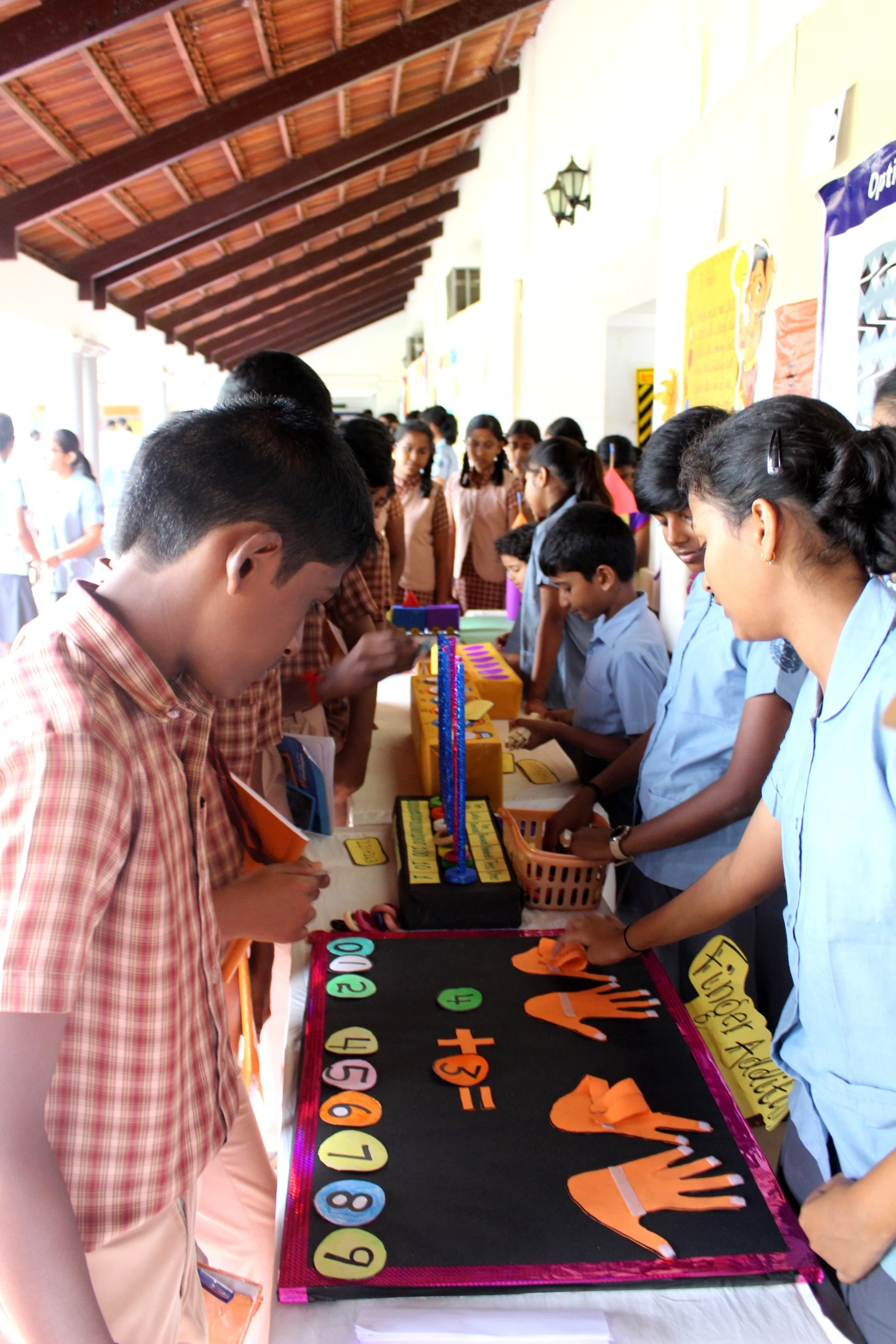 A student arranging handmade craft pieces on a display table