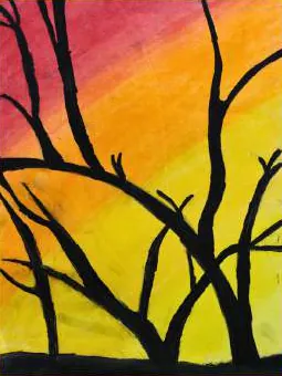 Black branches against an orange and yellow sky