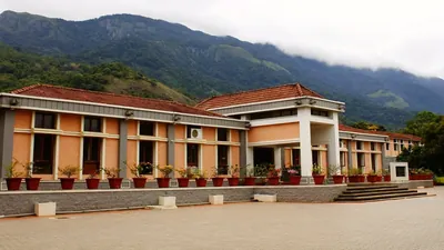 The school’s red-tiled buildings below forested hills under low cloud