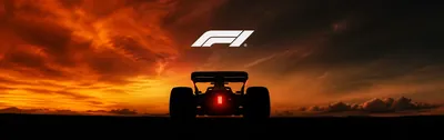 Rear view of a Formula 1 car silhouetted against a fiery sunset sky