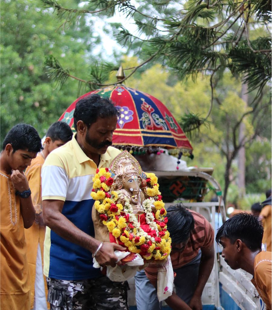 A group gathered outdoors with flower garlands