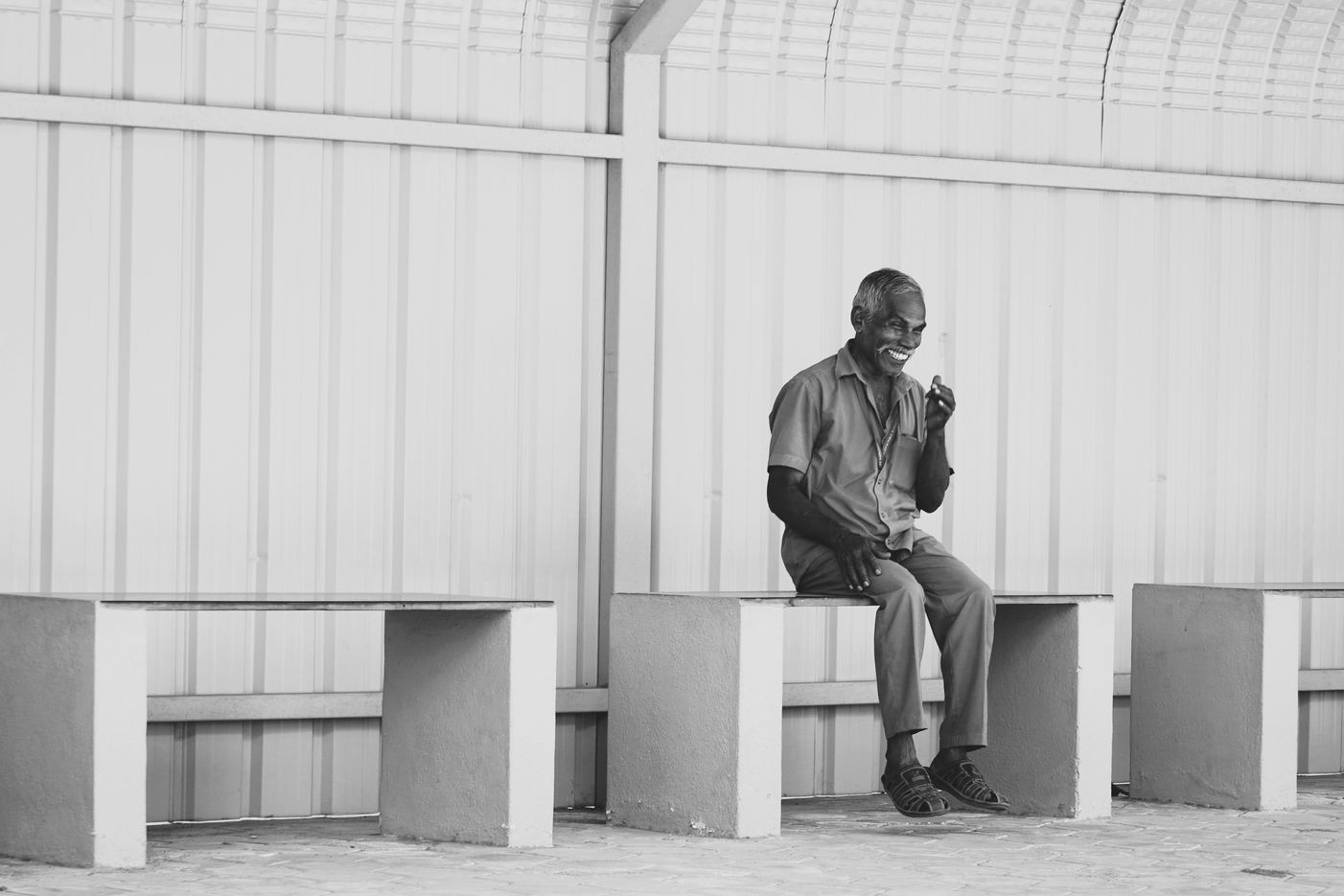 A man seated alone in a light corridor