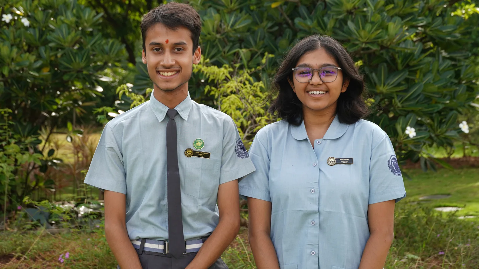 The two School Deans of the Student Council 2026–27 standing side by side among green plants