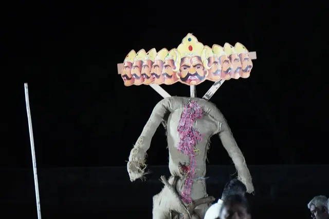 The ten-headed Ravan effigy standing on the dark field before it is lit