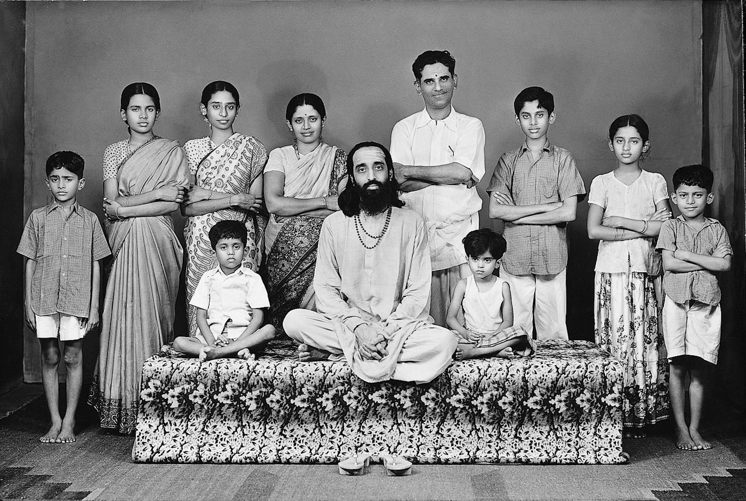 Swami Chinmayananda surrounded by children and members of a community