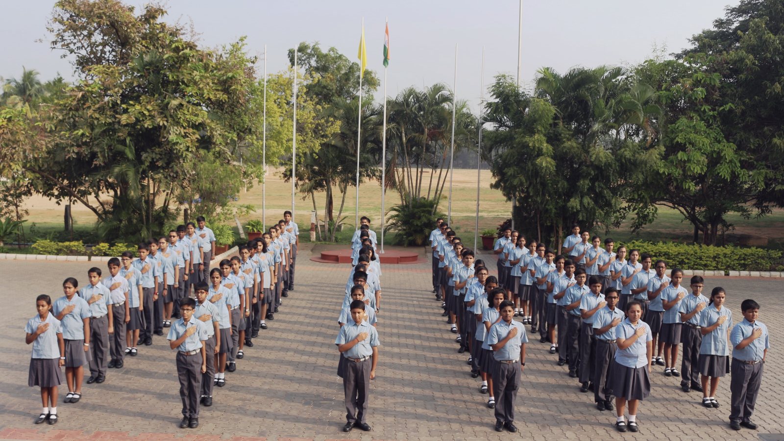 The school assembled in long rows on the paved ground