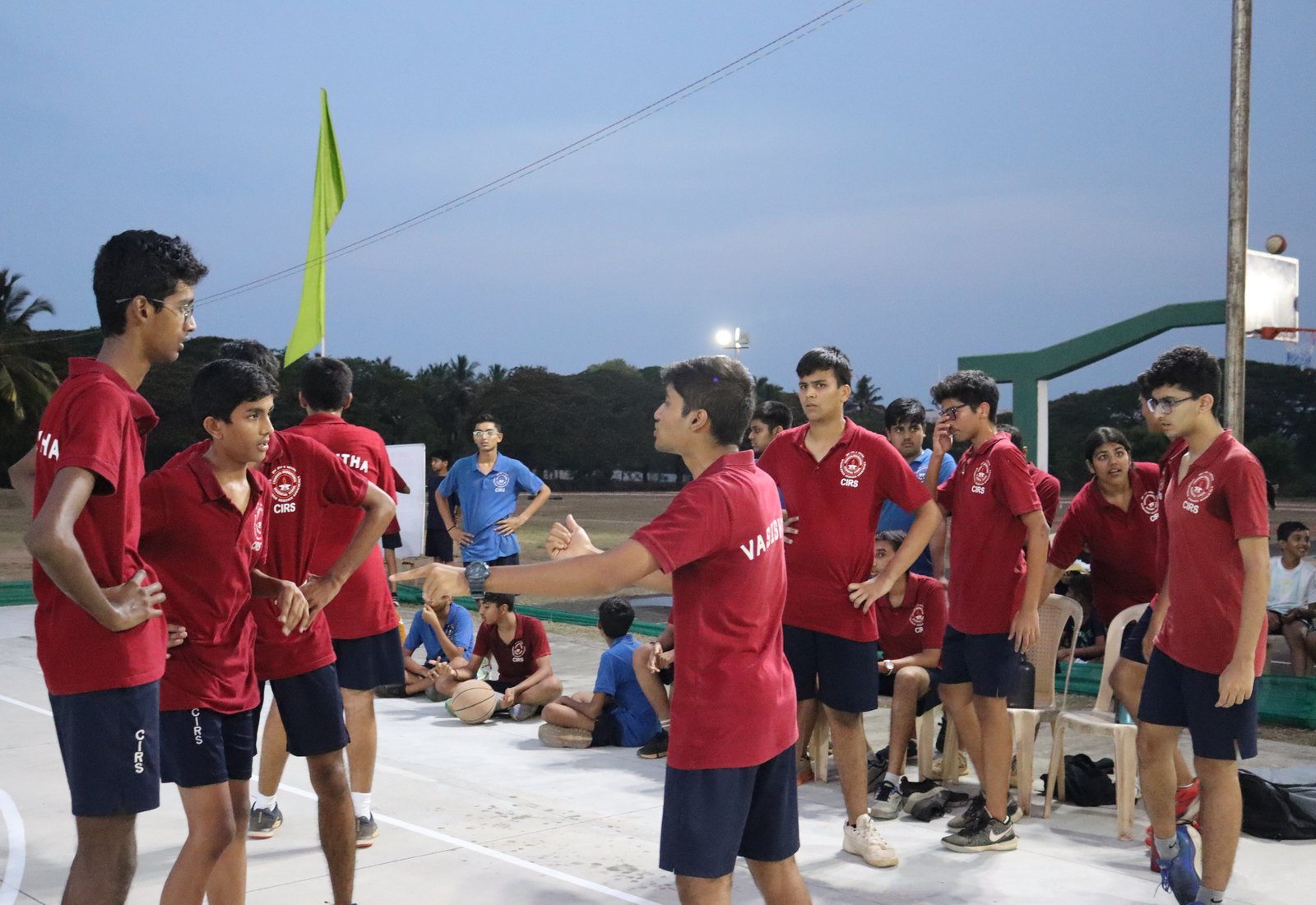 Vasishta players gathered on the basketball court in named red shirts
