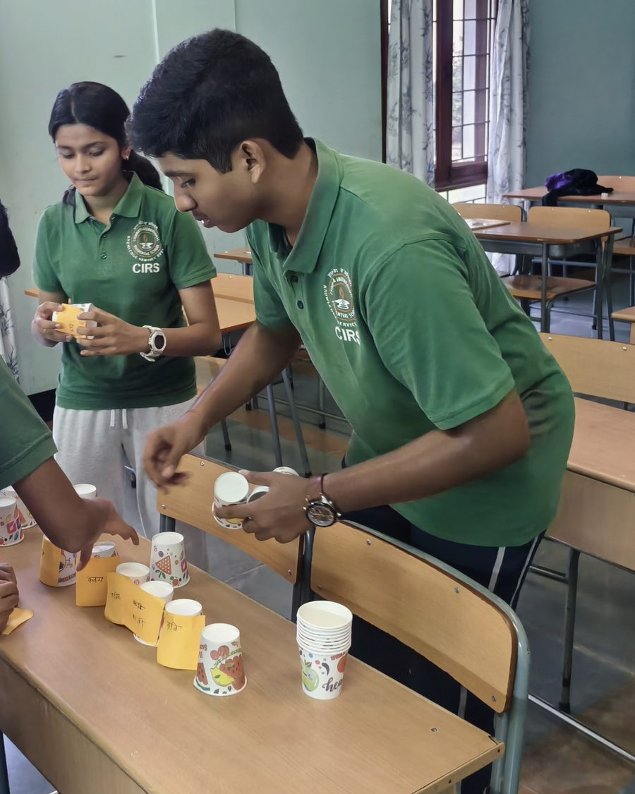 A CIRS student in a green shirt working at a desk during a classroom activity