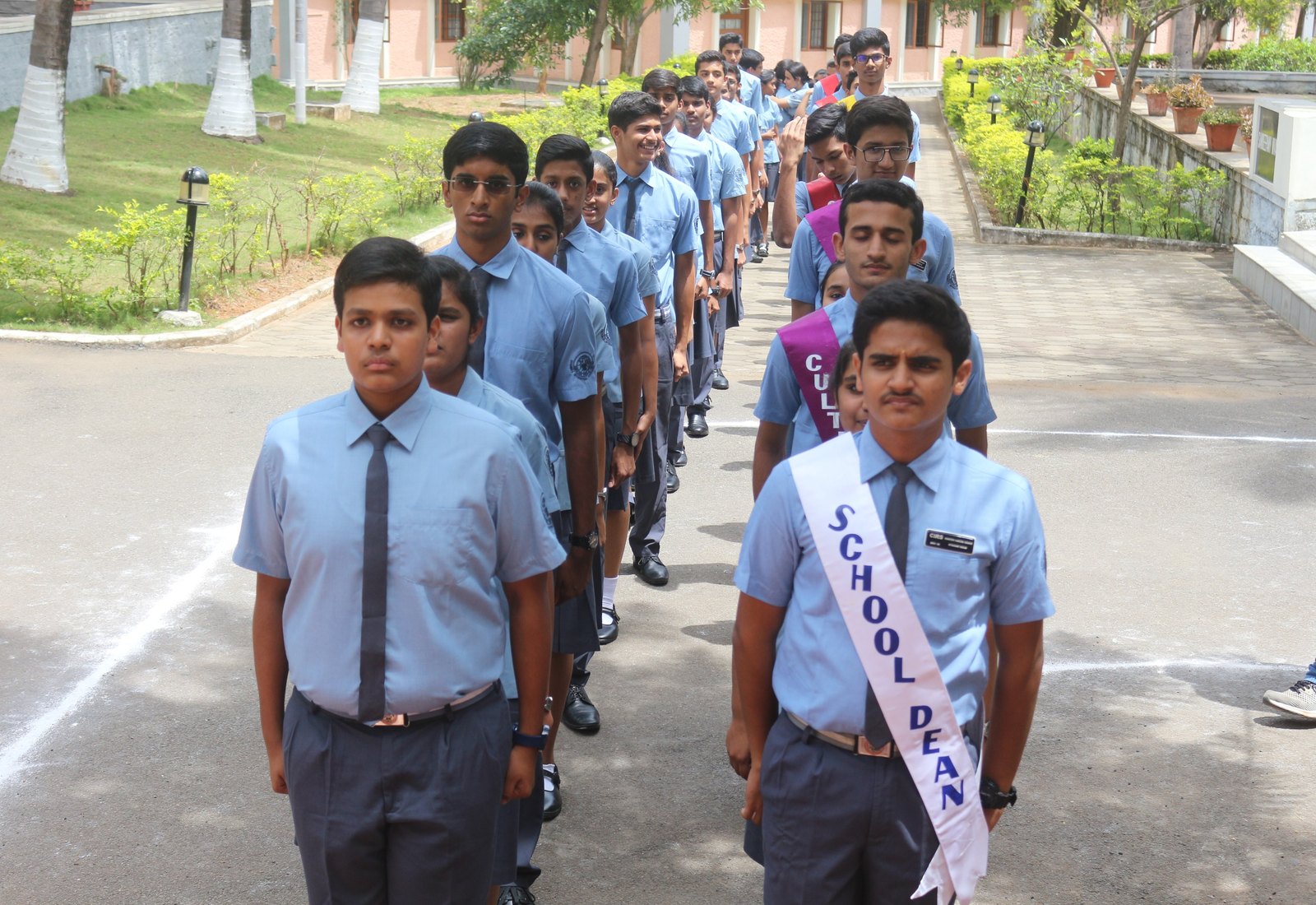 CIRS students walking in two rows, led by a student wearing a School Dean sash