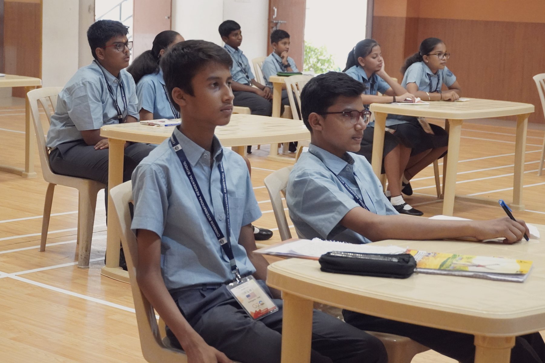 CIRS students in a lesson, seated at tables with their notebooks open