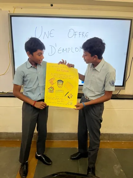 Two Class 10 students presenting their French job-offer poster