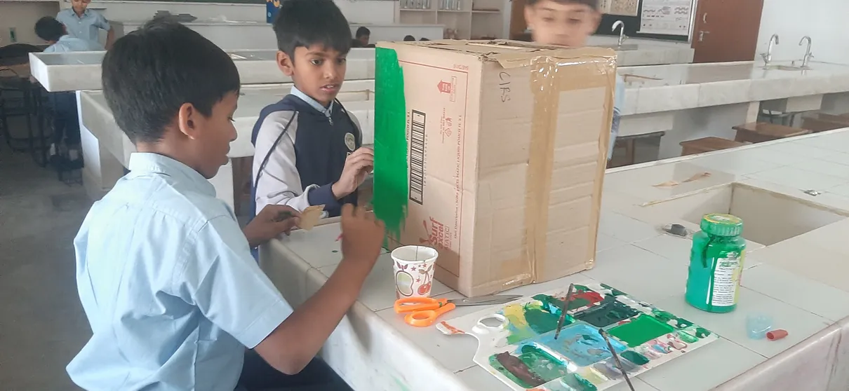 Grade 5 students making dustbins from waste materials