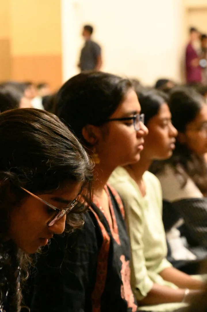 Students seated in a hall, listening