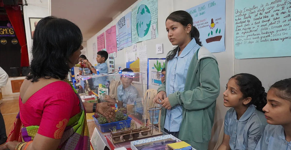 A CIRS student explaining a science exhibit to a visitor at the Science Expo