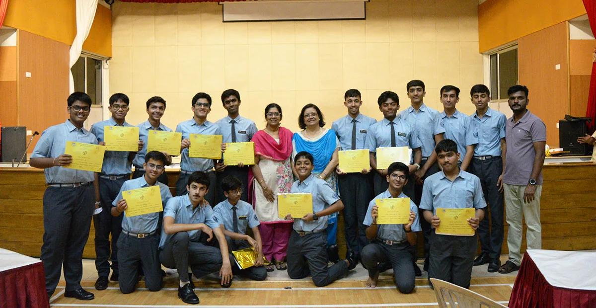 CIRS students and teachers holding certificates on a stage
