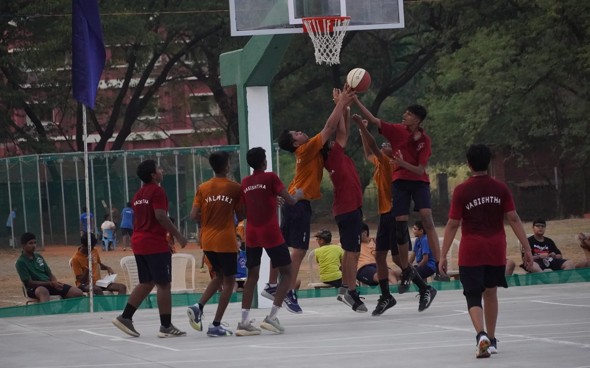 Players leaping for a rebound under the basket on the CIRS outdoor court