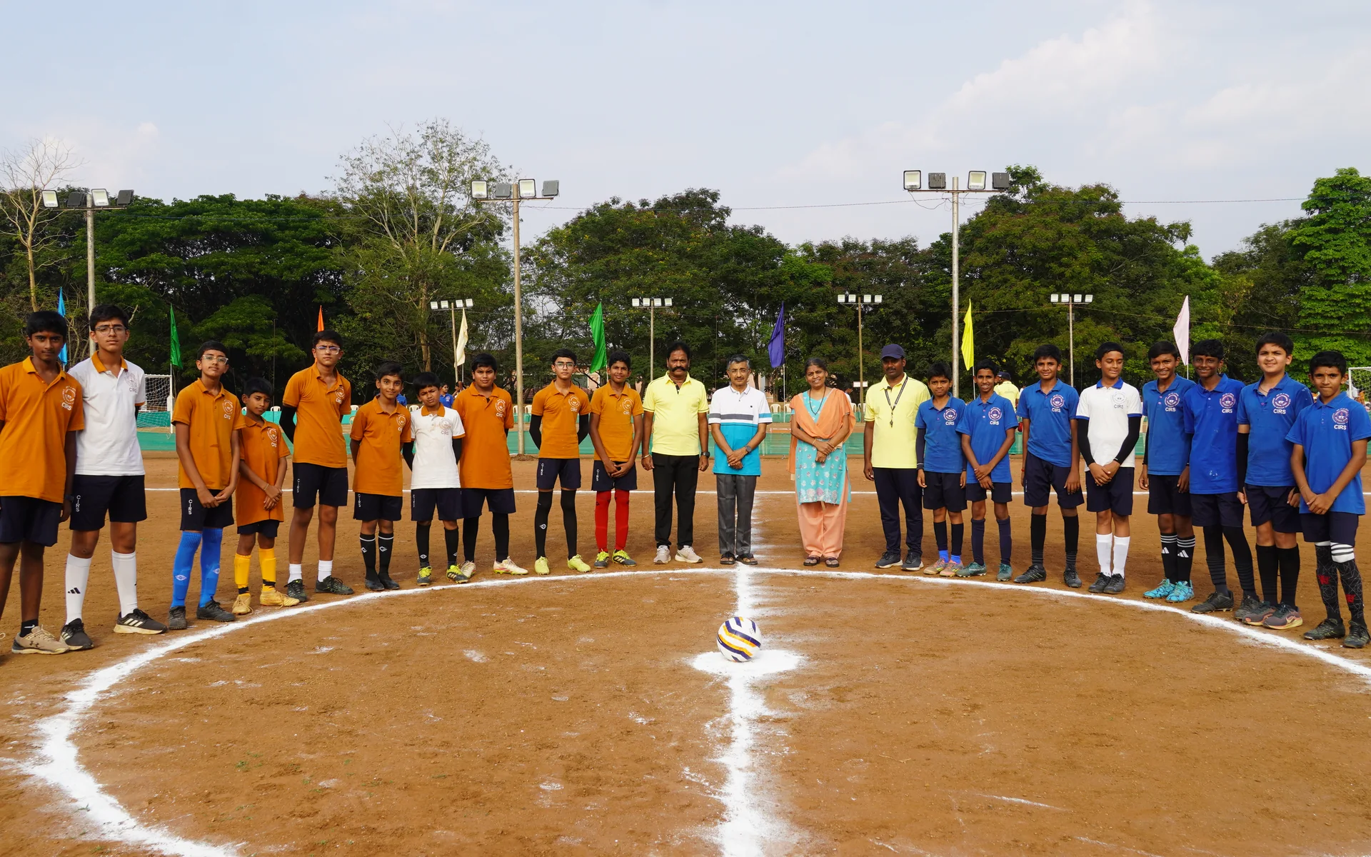 CIRS teams and staff gathered around a football on the playing field