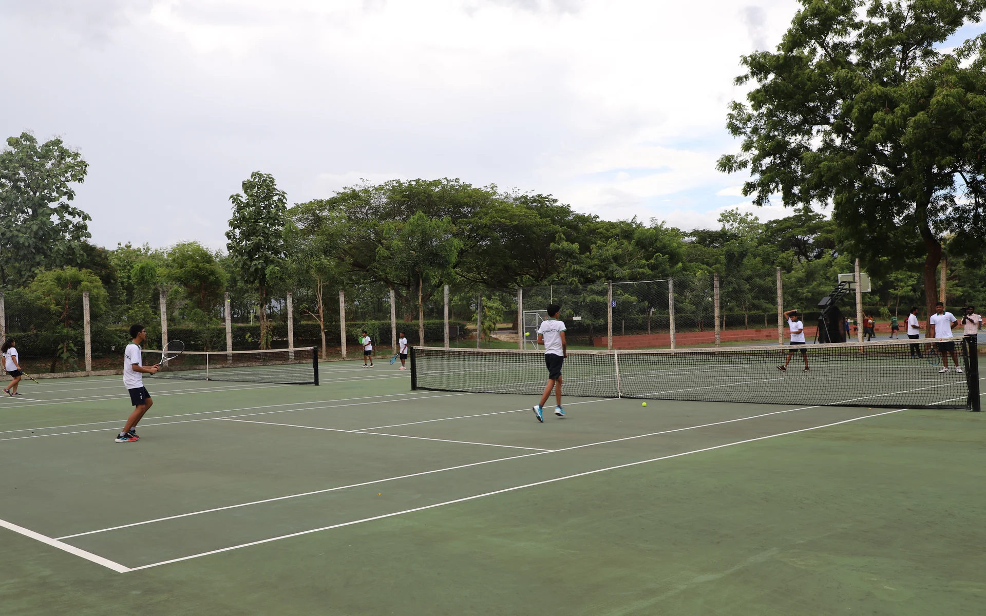 Students play across the outdoor tennis courts at CIRS
