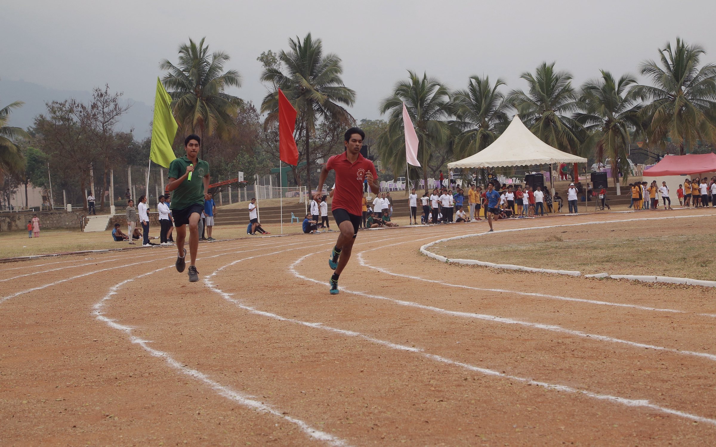 Runners rounding the CIRS athletics track against the Western Ghats