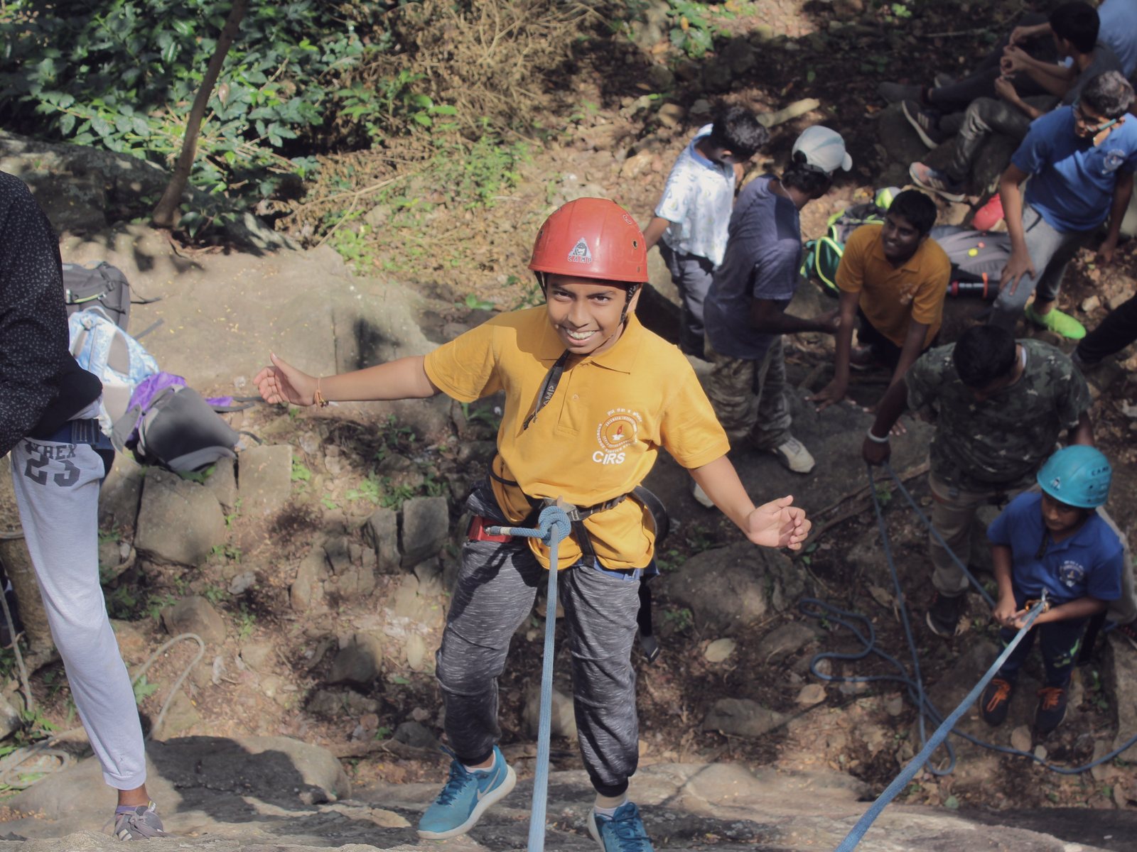 A CIRS student wearing a helmet and harness while climbing outdoors