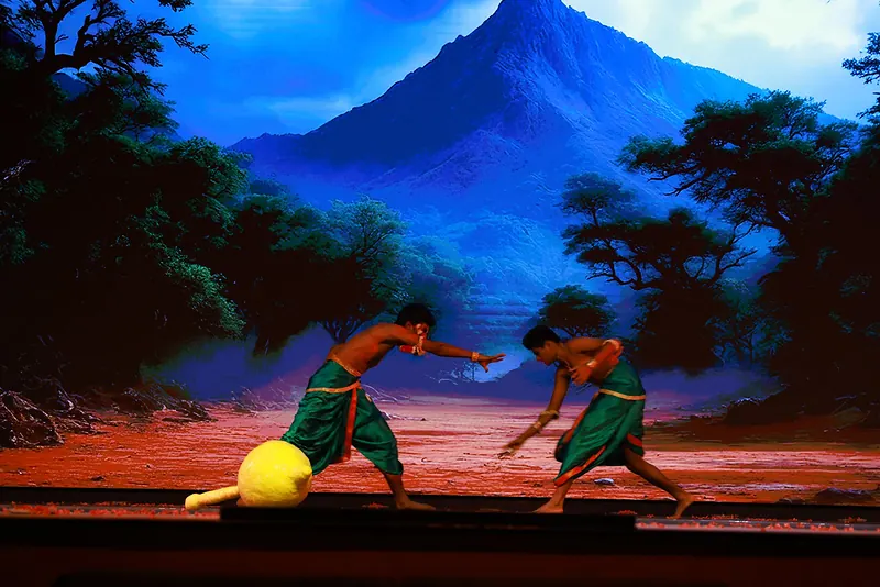 Two students in green dhotis grappling before a painted blue mountain