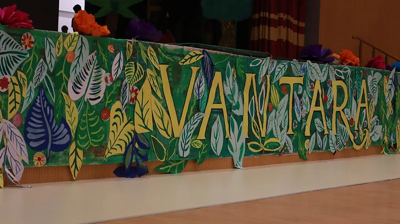 A painted banner of jungle leaves reading Vantara along the front of the stage