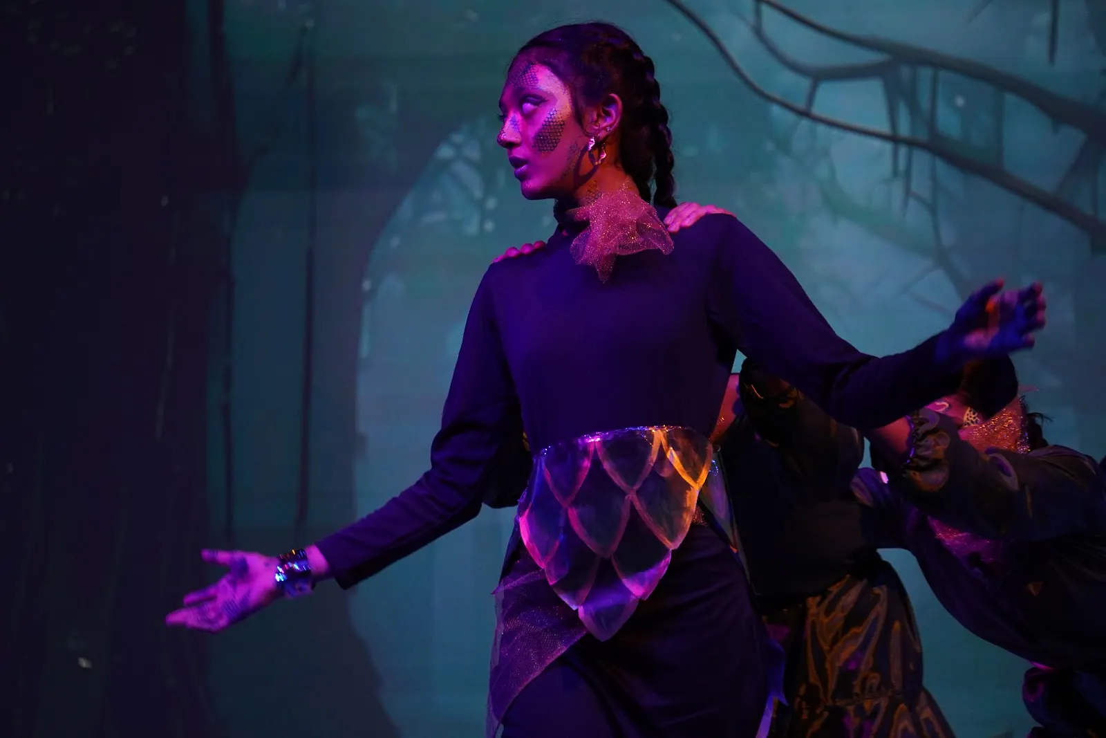 A Vasishta performer under violet stage light in Vantara